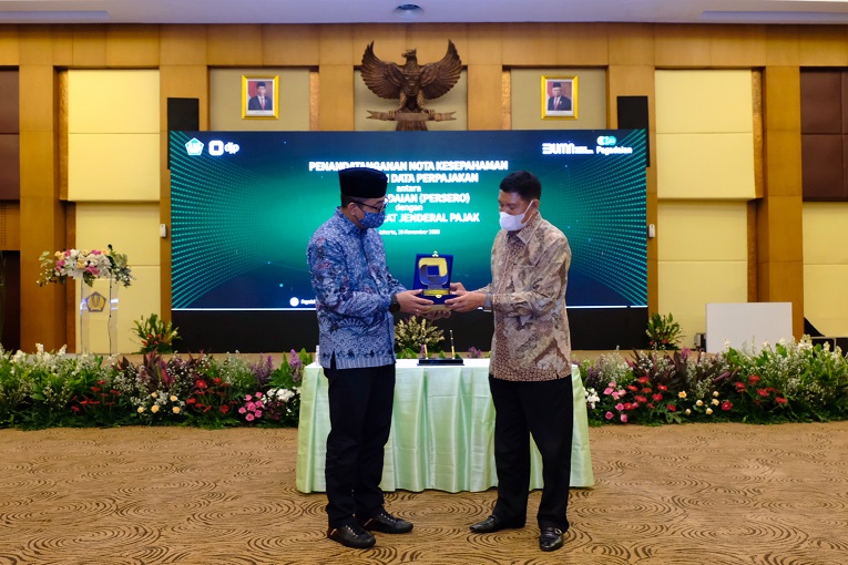 Dirjen Pajak Suryo Utomo dan Direktur Utama PT Pegadaian (Persero) Kuswiyoto bertukar cendera mata