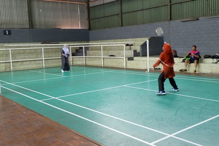 Pegawai pria maupun wanita pecinta olahraga badminton bermain di lapangan sewaan tidak jauh dari kantor