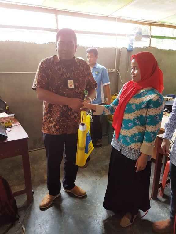 Penyerahan suvenir kepada salah satu peserta sosialisasi yang aktif bertanya oleh David Henry D Manalu di penghujung acara