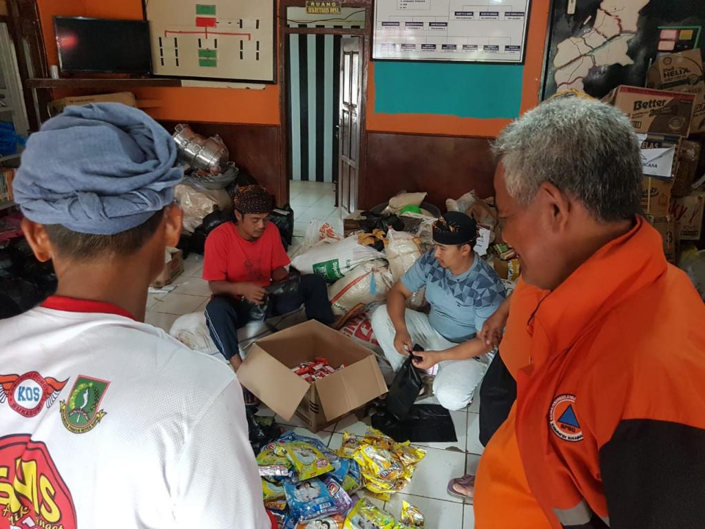 Situasi di Balai Desa Sirnaresmi, para relawan sedang memilah jenis bantuan yang diterima warga