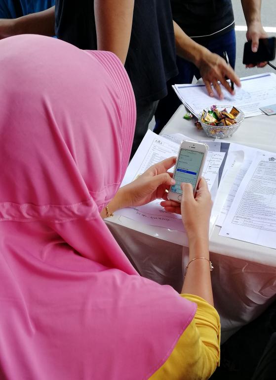 Salah satu pengunjung dibantu tim KPP Pratama Bojonegoro untuk pembuatan efiling melalui telepon pintar