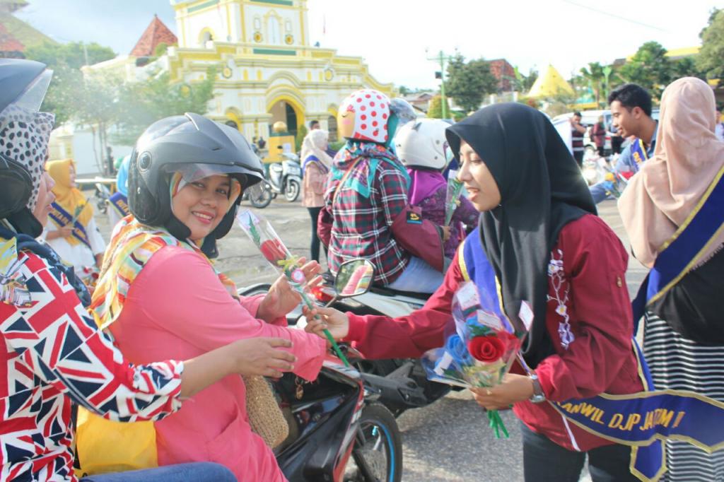 Salah Seorang pengendara sepeda motor menerima bunga senang hati,