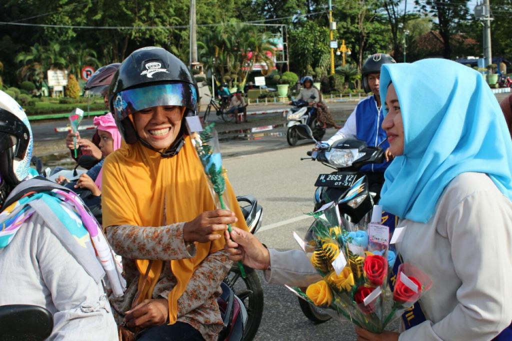 Duta pajak membagikan bunga kepada pengendara motor