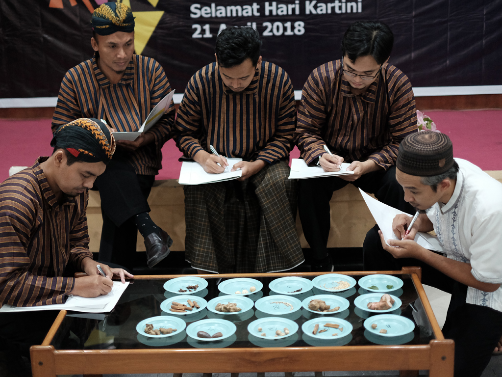 Bapak bapak dengan setelan luriknya berusaha mengidentifikasi bumbu masak di depannya